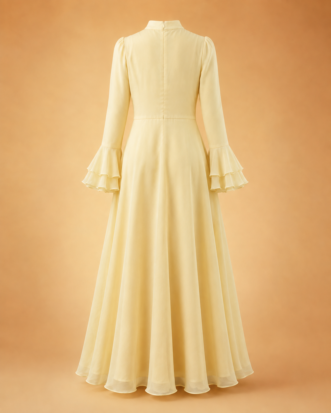A pale yellow chiffon maxi dress with long bell sleeves and ruffled cuffs, shown from the back against a warm peach background.